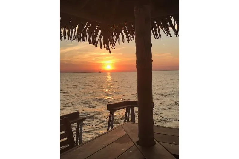 Slide: The Image of Sunset view from a Big Hut 26, 2023, over calm ocean waters. - 6