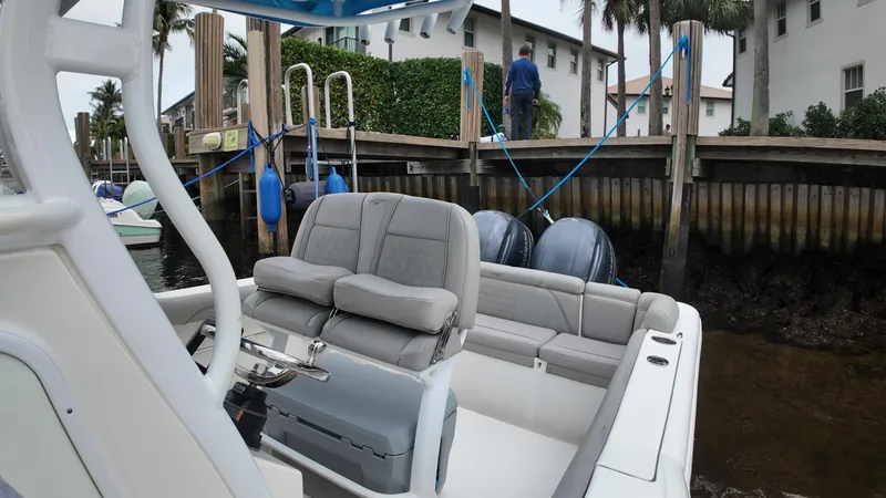 Slide: The Image of 2017 Tidewater 252 LXF boat docked, featuring comfortable seating and dual outboard motors. - 28