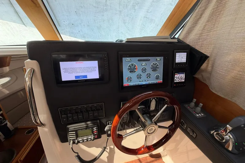 Slide: The Image of 2019 Cutwater C-28 helm with Garmin displays and wooden steering wheel. - 10