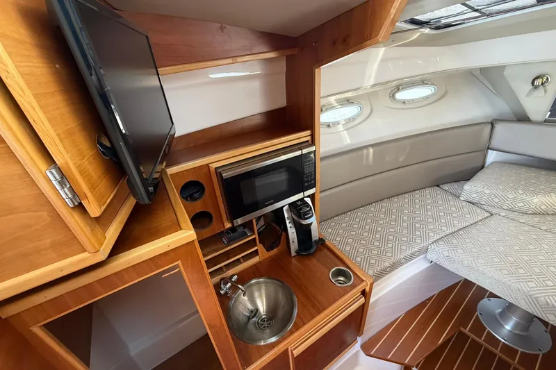 Slide: The Image of 2019 Cutwater C-28 cabin interior with kitchenette, TV, and cozy seating area. - 11