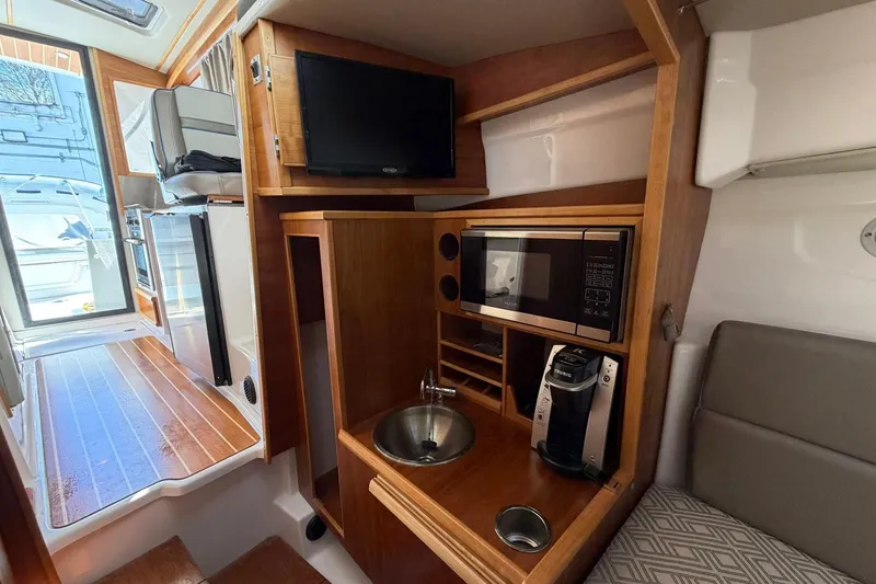 Slide: The Image of 2019 Cutwater C-28 interior with kitchenette, featuring microwave, sink, and coffee maker. - 14