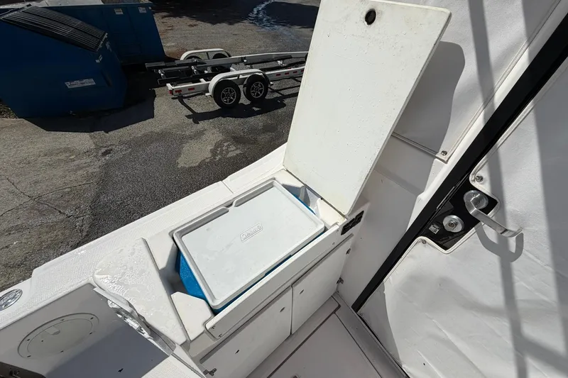Slide: The Image of Open storage compartment on 2019 Cutwater C-28 boat, revealing a cooler inside. - 15