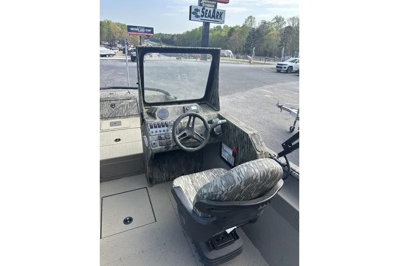 Slide: The Image of 2025 SeaArk Predator 300 AK boat interior with steering wheel and camo seat. - 10