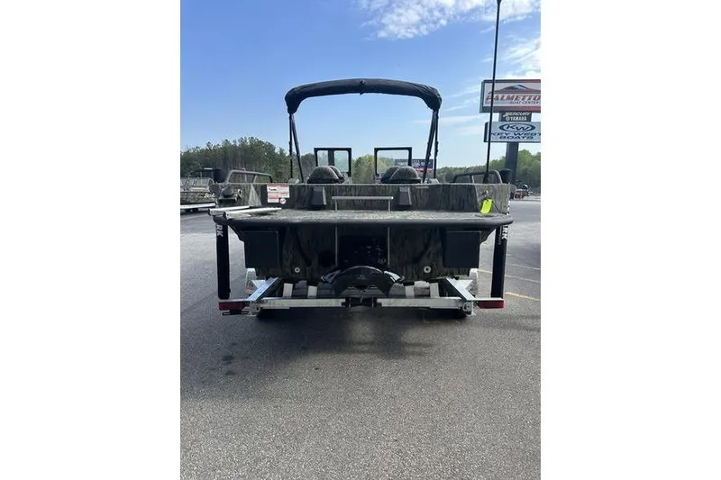 Slide: The Image of 2025 SeaArk Predator 300 AK boat on trailer, rear view, outdoor setting. - 17