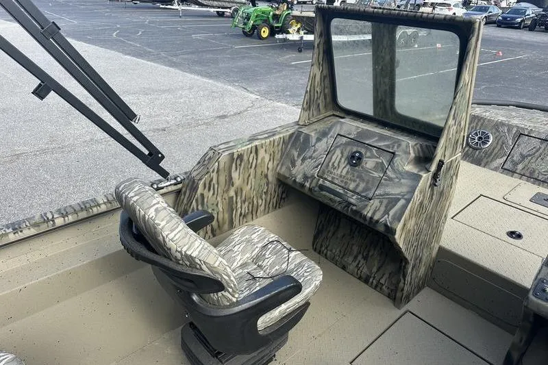 Slide: The Image of 2025 SeaArk Predator 300 AK boat interior with camouflage seating and console. - 18