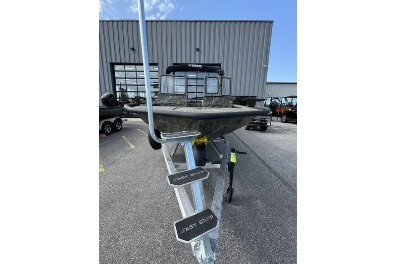 Slide: The Image of 2025 SeaArk Predator 300 AK boat on trailer, parked outside a building. - 3