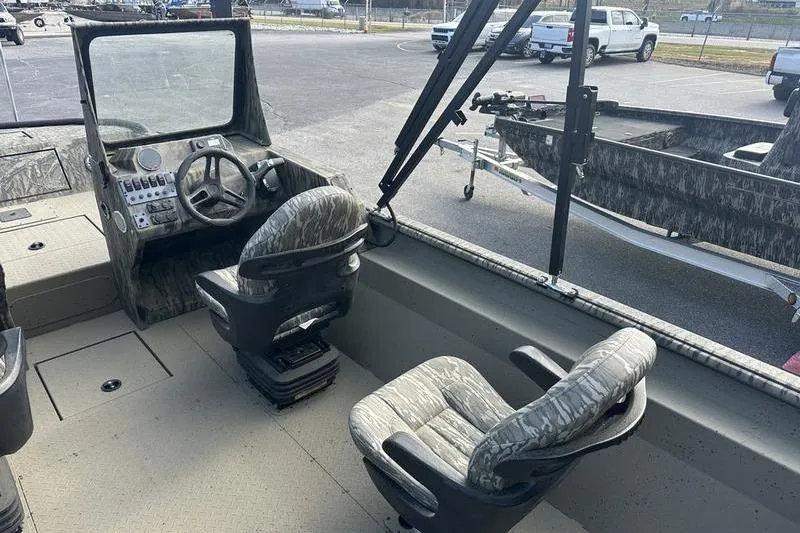 Slide: The Image of 2025 SeaArk Predator 300 AK boat interior with camo seats and steering console. - 5