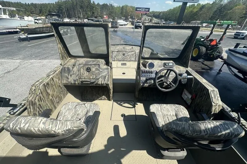 Slide: The Image of 2025 SeaArk Predator 300 AK boat interior with camouflage seating and steering console. - 7