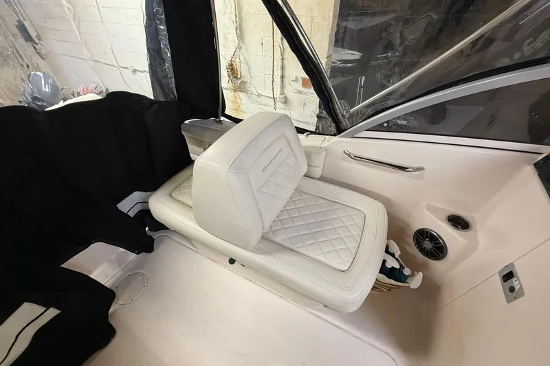 Slide: The Image of 2022 Grady-White Freedom 215 boat interior with white cushioned seating and speaker. - 19