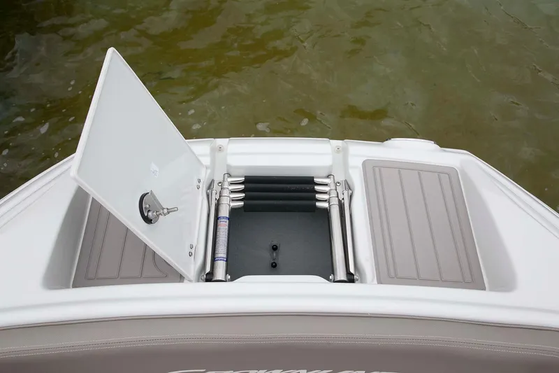 Slide: The Image of 2024 Crownline Eclipse E240 XS boat with open storage compartment and ladder. - 10