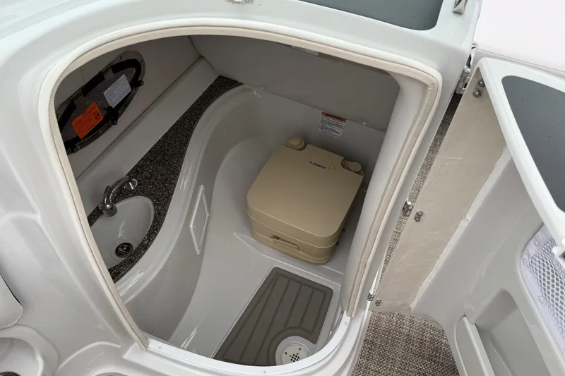 Slide: The Image of 2024 Crownline Eclipse E240 XS boat interior with compact bathroom and sink. - 6
