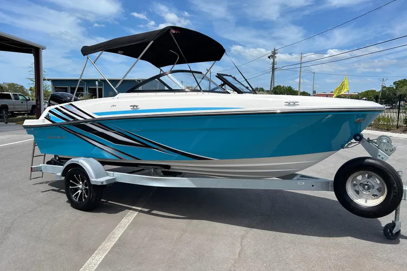 The Image of 2023 Bayliner VR4 Bowrider OB in blue on trailer, parked outdoors. - 1