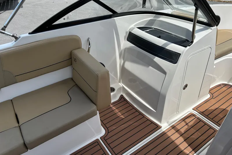 Slide: The Image of 2023 Bayliner VR4 Bowrider OB interior with tan seating and wood-style flooring. - 11