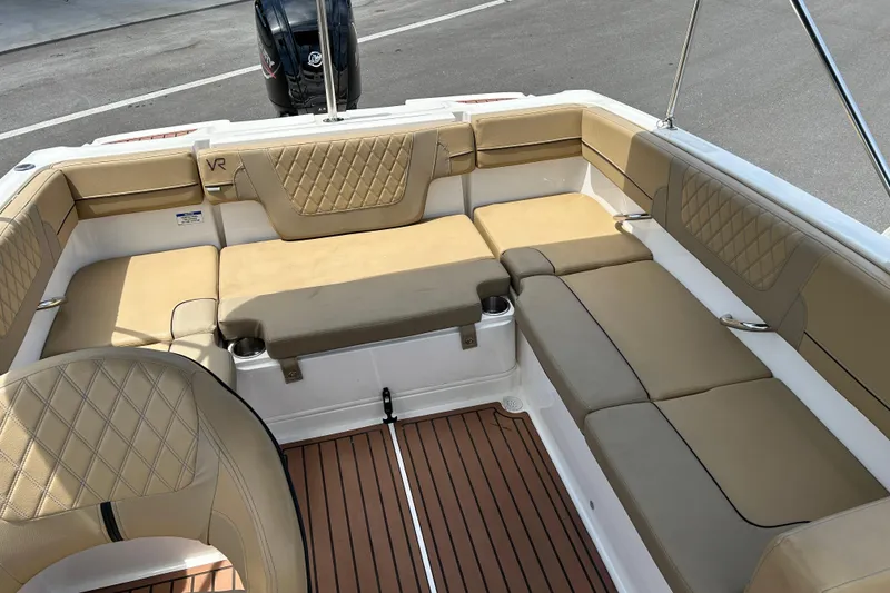 Slide: The Image of 2023 Bayliner VR4 Bowrider OB interior with tan cushioned seating and wood-style flooring. - 12
