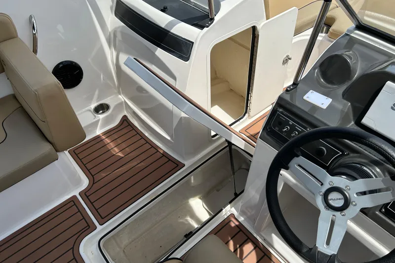 Slide: The Image of 2023 Bayliner VR4 Bowrider OB interior with steering wheel and seating area. - 14