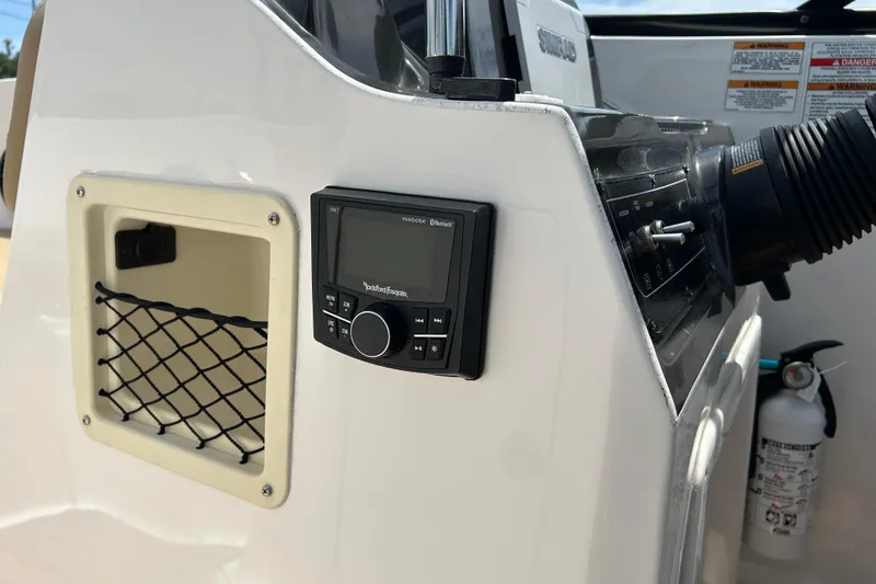 Slide: The Image of 2023 Bayliner VR4 Bowrider OB dashboard with stereo system and storage compartment. - 16