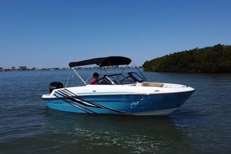 Slide: The Image of 2023 Bayliner VR4 Bowrider OB on calm water, featuring sleek design and blue hull. - 18