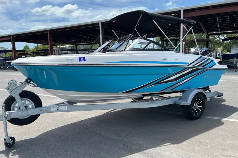 Slide: The Image of 2023 Bayliner VR4 Bowrider OB in vibrant blue on a trailer, parked outdoors. - 5