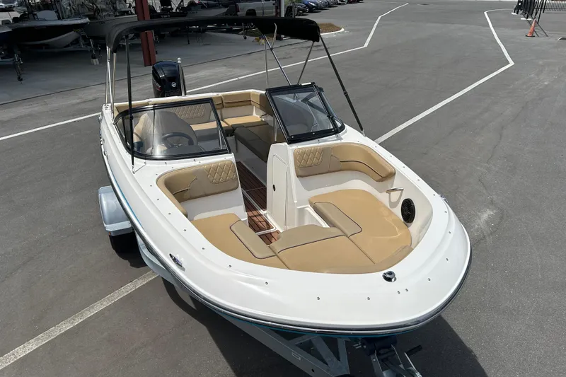 Slide: The Image of 2023 Bayliner VR4 Bowrider OB boat with tan seating, parked on a trailer. - 6