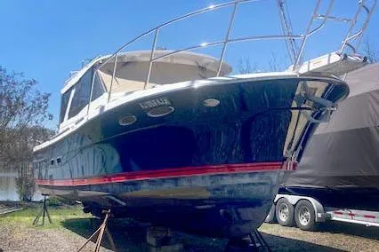 The Image of 2018 Cutwater C-30 Sedan boat on stands, blue hull with red stripe, parked outdoors. - 0