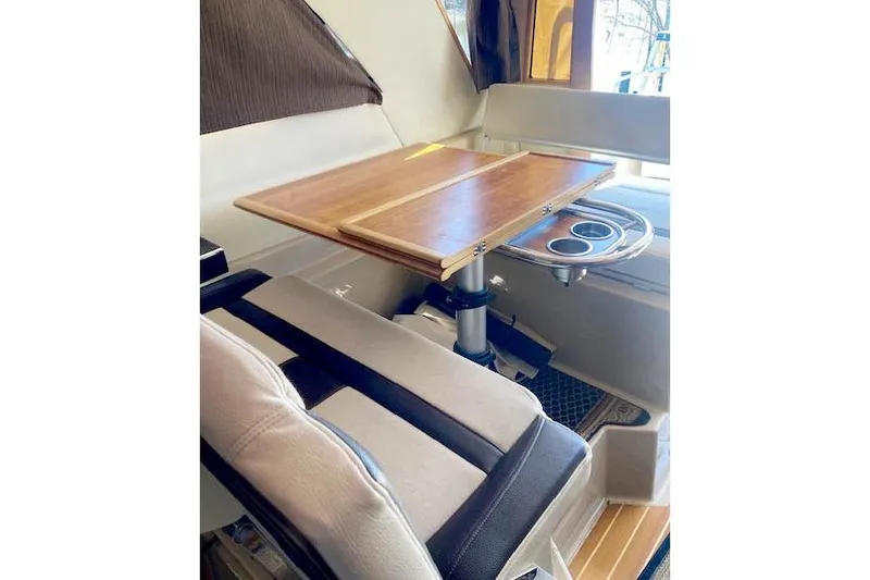 Slide: The Image of 2018 Cutwater C-30 Sedan interior with wooden table and cushioned seating. - 16