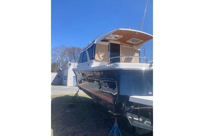 Slide: The Image of 2018 Cutwater C-30 Sedan boat on land, blue hull, sunny day. - 2