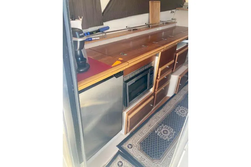 Slide: The Image of 2018 Cutwater C-30 Sedan interior kitchen with wooden cabinets and modern appliances. - 21