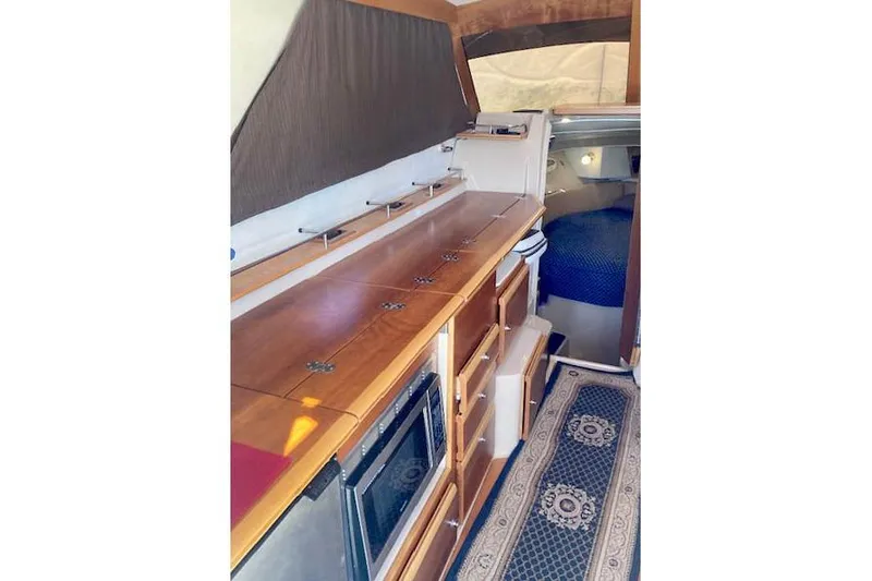 Slide: The Image of Interior of 2018 Cutwater C-30 Sedan, featuring a wooden galley and cozy cabin space. - 22