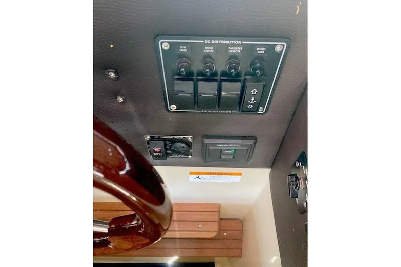 Slide: The Image of Control panel of a 2018 Cutwater C-30 Sedan boat with switches and steering wheel. - 25