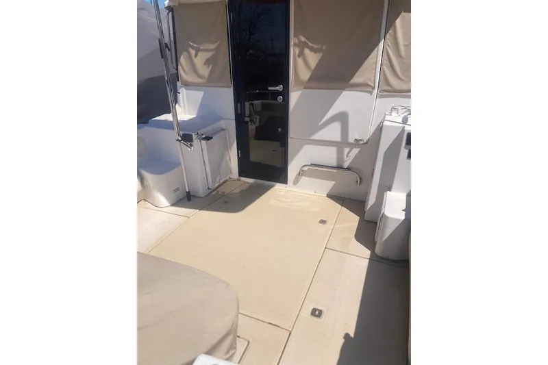 Slide: The Image of 2018 Cutwater C-30 Sedan boat interior with beige flooring and covered seating area. - 5
