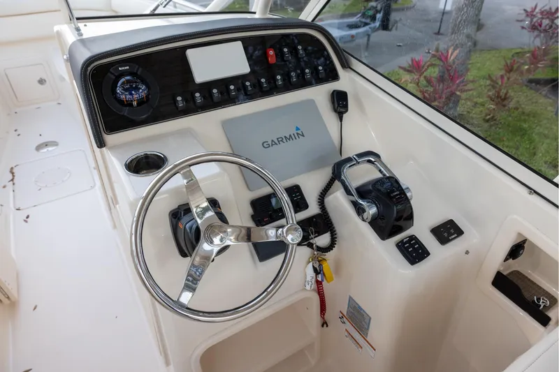 Slide: The Image of 2018 Grady-White Freedom 285 boat dashboard with Garmin navigation system and steering wheel. - 10