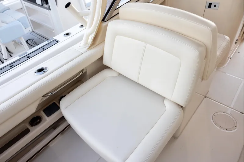 Slide: The Image of 2018 Grady-White Freedom 285 boat interior with white seating and rod holders. - 8