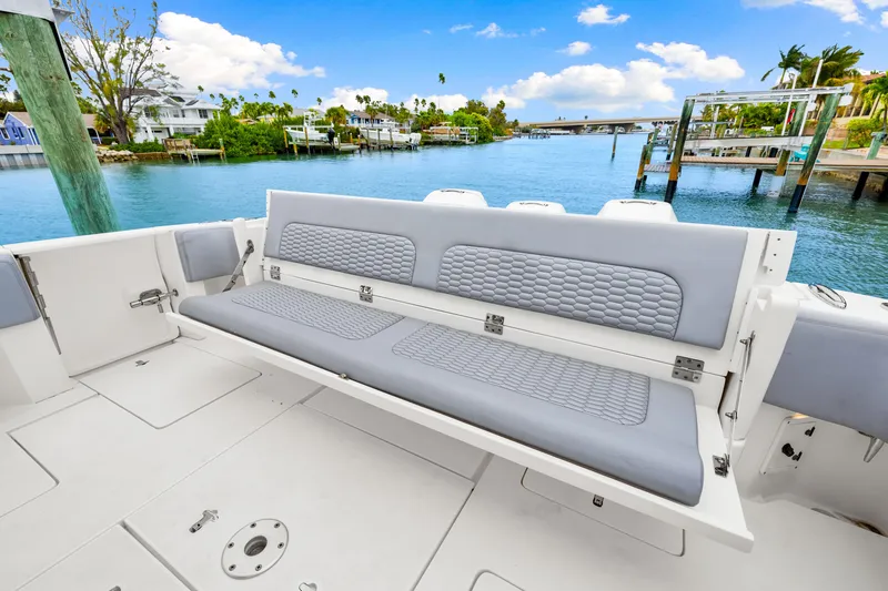 Slide: The Image of 2019 Intrepid 410 Evolution boat with gray seating, docked by a scenic waterfront. - 22