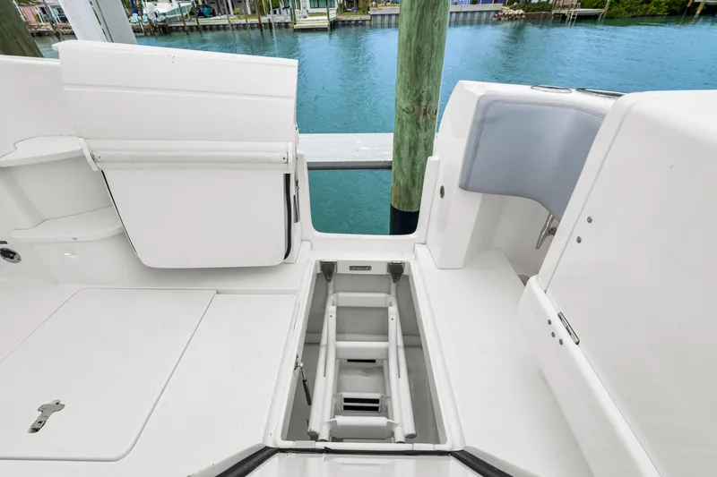 Slide: The Image of 2019 Intrepid 410 Evolution boat deck with open storage compartment by the water. - 24