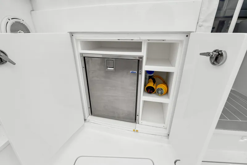 Slide: The Image of Storage compartment on a 2019 Intrepid 410 Evolution boat with stainless steel fridge and shelves. - 26