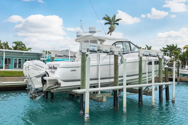 Slide: The Image of 2019 Intrepid 410 Evolution boat on lift, docked in tropical marina setting. - 3