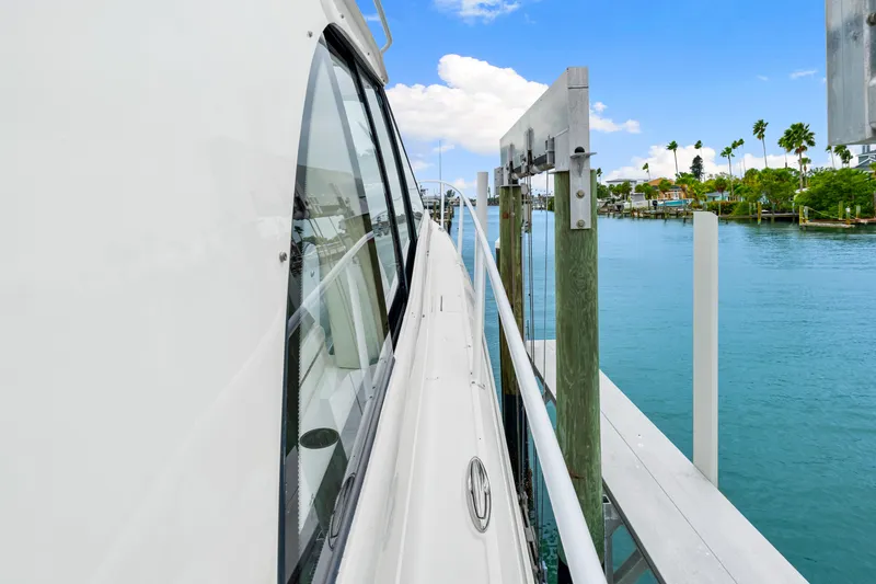 Slide: The Image of Side view of 2019 Intrepid 410 Evolution yacht docked by clear blue water. - 31