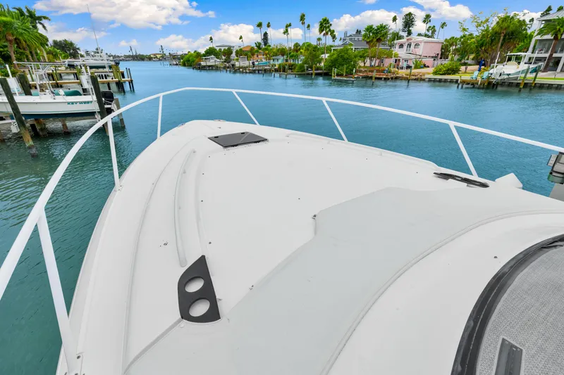 Slide: The Image of 2019 Intrepid 410 Evolution yacht cruising in a scenic waterfront area. - 33