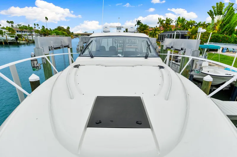Slide: The Image of 2019 Intrepid 410 Evolution yacht docked in a scenic marina setting. - 34