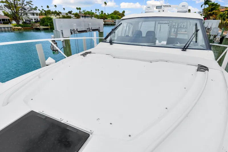 Slide: The Image of 2019 Intrepid 410 Evolution yacht docked by serene waterfront. - 35