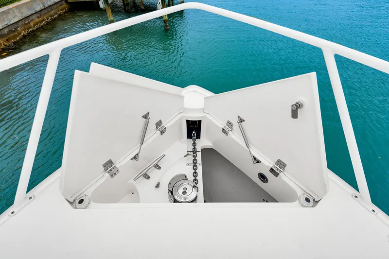 Slide: The Image of Anchor compartment of 2019 Intrepid 410 Evolution boat with open hatch, dockside view. - 36