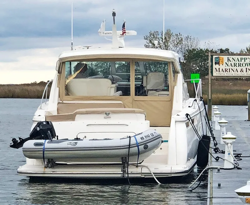 Slide: The Image of 2009 Tiara Yachts 4300 Sovran docked at marina with inflatable boat attached. - 19