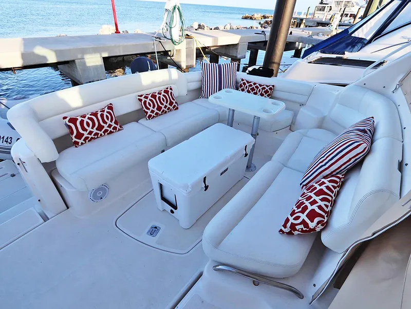 Slide: The Image of 2009 Tiara Yachts 4300 Sovran deck with white seating and red-patterned cushions. - 20