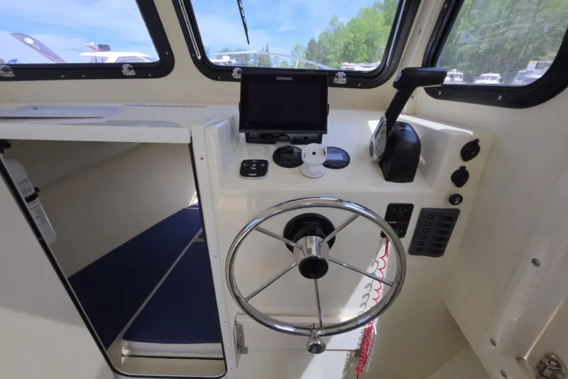 Slide: The Image of Interior helm of 2018 Rosborough 22 Cape Breton boat with steering wheel and navigation controls. - 18