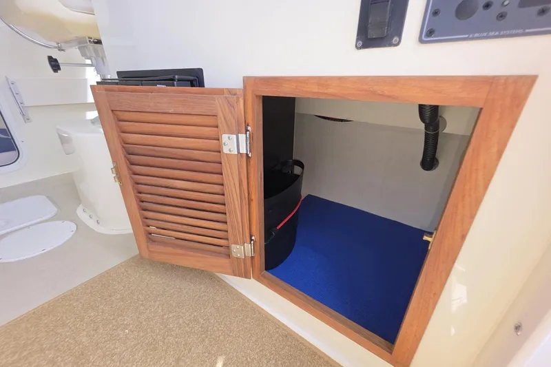 Slide: The Image of Open wooden cabinet on 2018 Rosborough 22 Cape Breton boat, revealing interior storage space. - 23