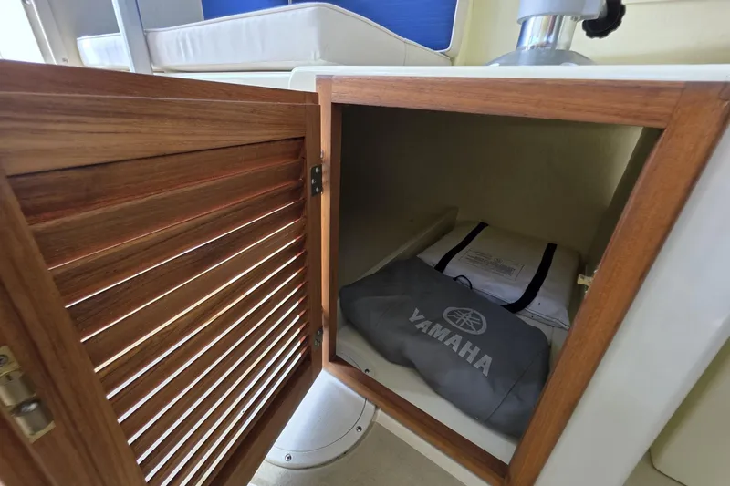 Slide: The Image of Open wooden cabinet on 2018 Rosborough 22 Cape Breton boat, storing Yamaha equipment. - 24