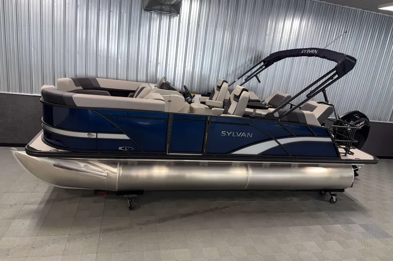 The Image of 2026 Sylvan L1 LZ pontoon boat with blue and silver design in showroom. - 1