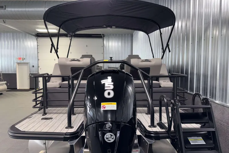 Slide: The Image of 2026 Sylvan L1 LZ pontoon boat with 150 HP engine in a showroom. - 27