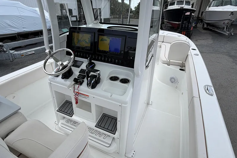 Slide: The Image of 2021 Sea Hunt Escape 27 boat cockpit with steering wheel and navigation screens. - 3
