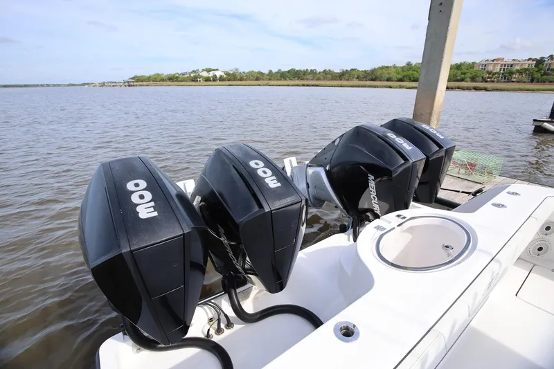 Slide: The Image of Four powerful outboard motors on a 2020 Invincible 35 Catamaran docked by the water. - 10